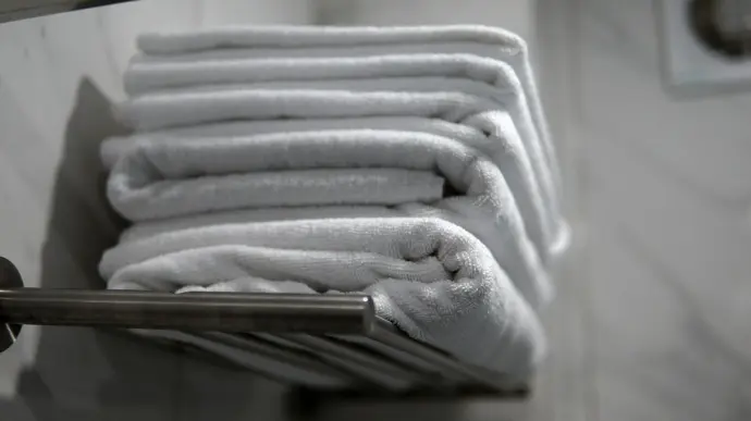 A stack of folded towels sitting on a towel rack